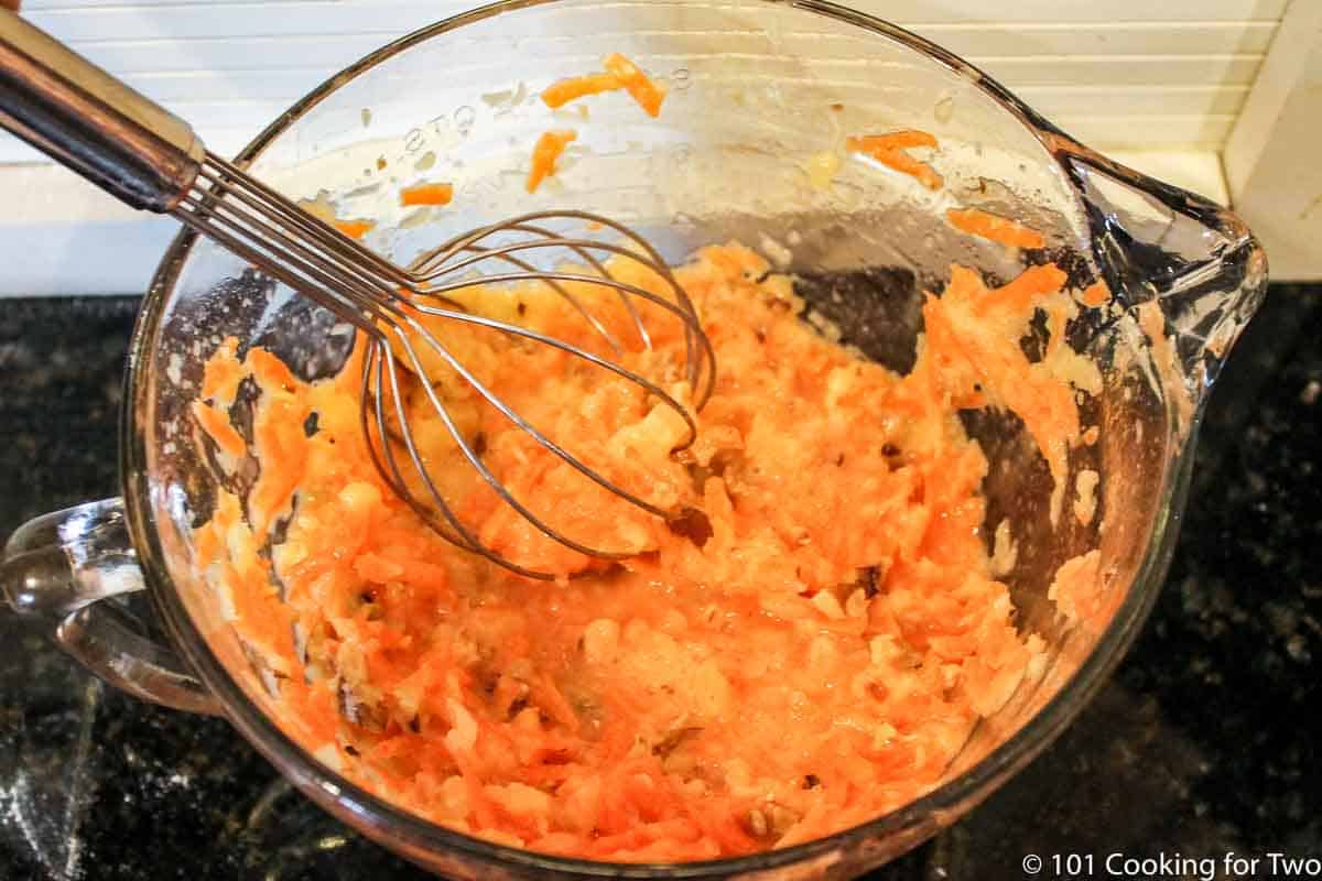 mixing shredded carrots into wet ingredients.