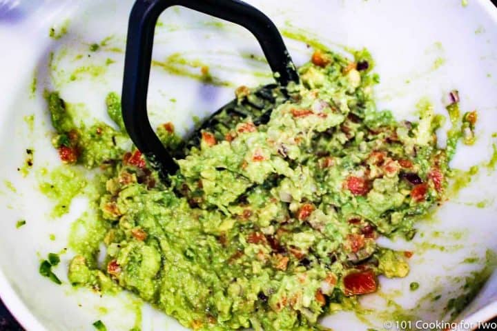 mixing the guacamole together in a bowl