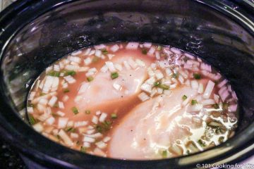 raw chicken in the crock pot with broth