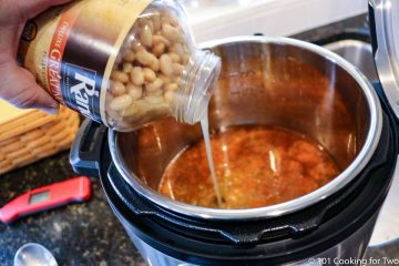 adding a jar of beans to the cooker