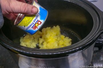 adding crushed pineapple to a small crock pot