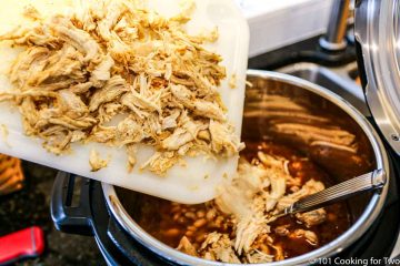 adding shredded chicken to the to the cooker