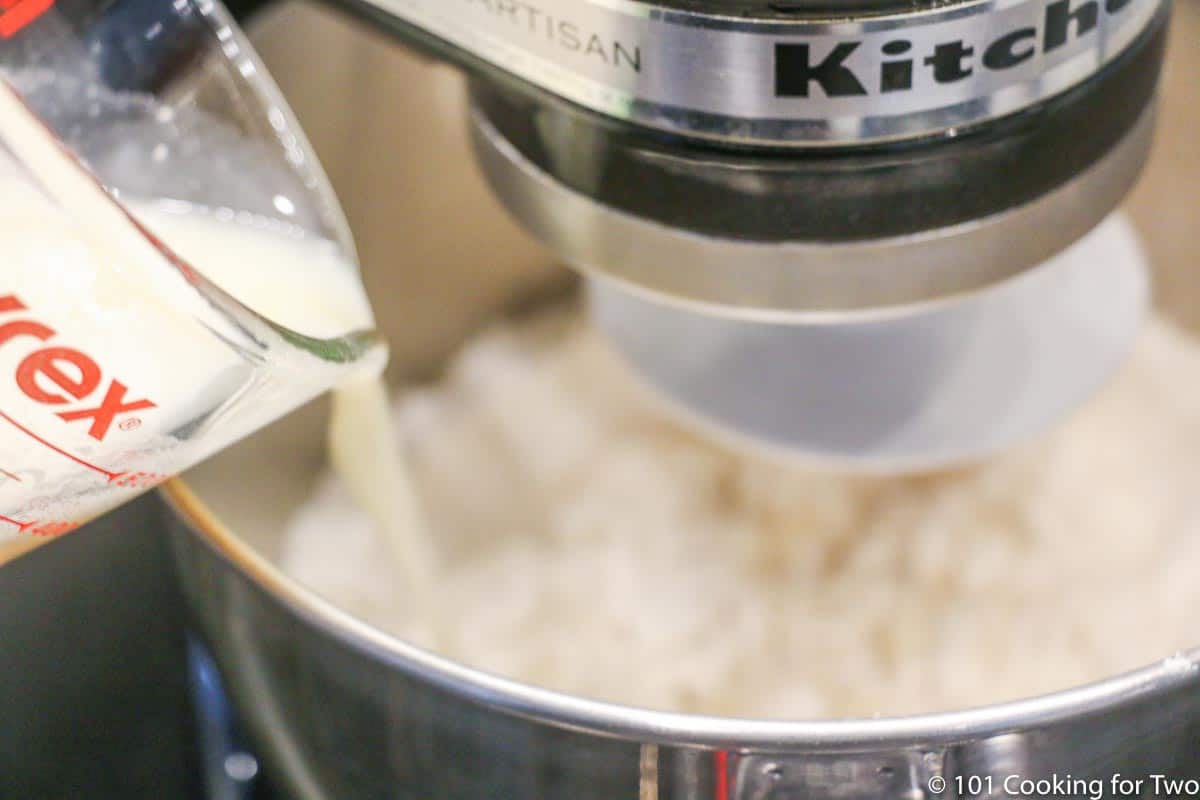 adding the yeast mixture to the stand mixer.