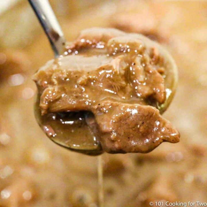 beef tips with gravy in a ladle