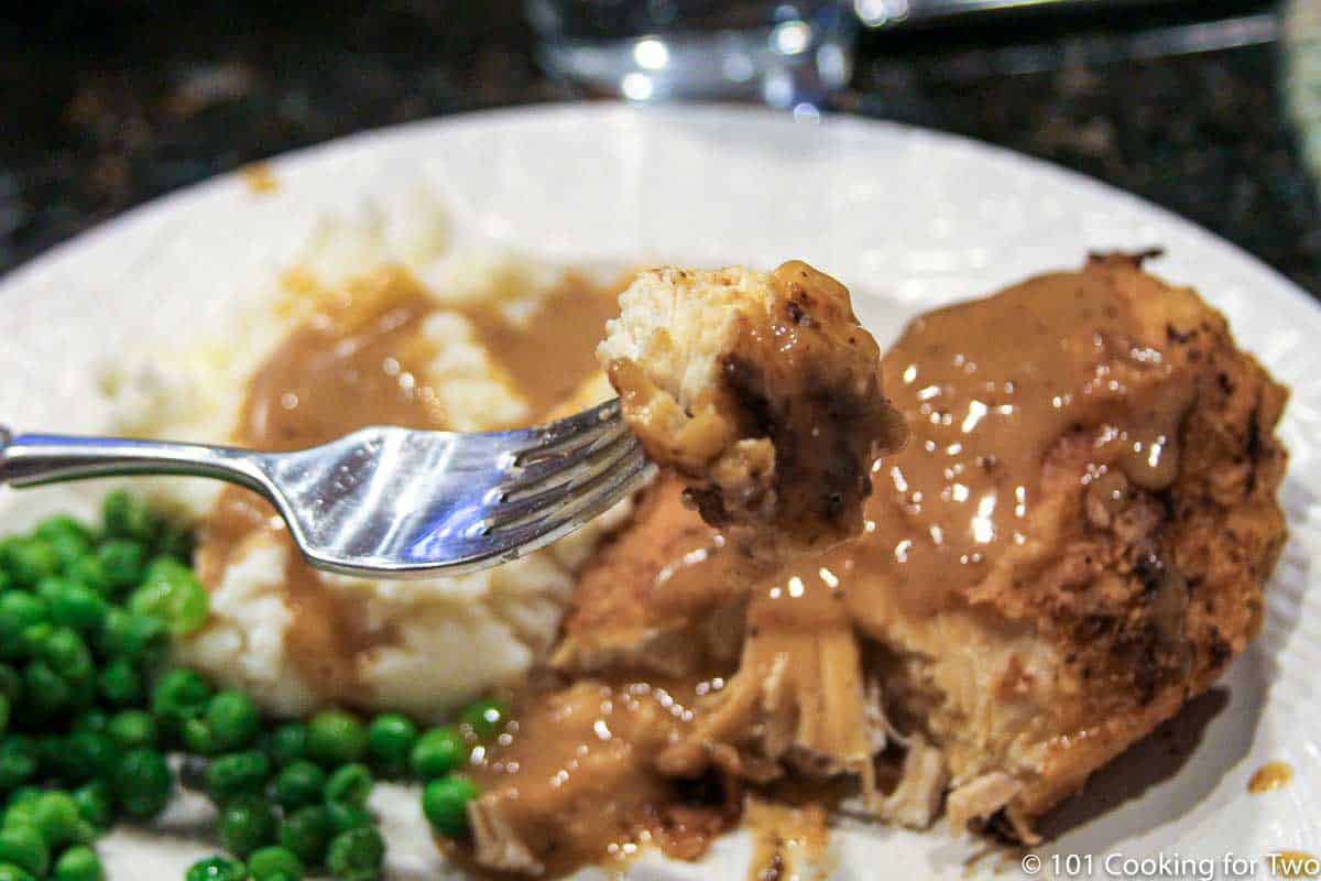 bite of fried chicken on a fork.