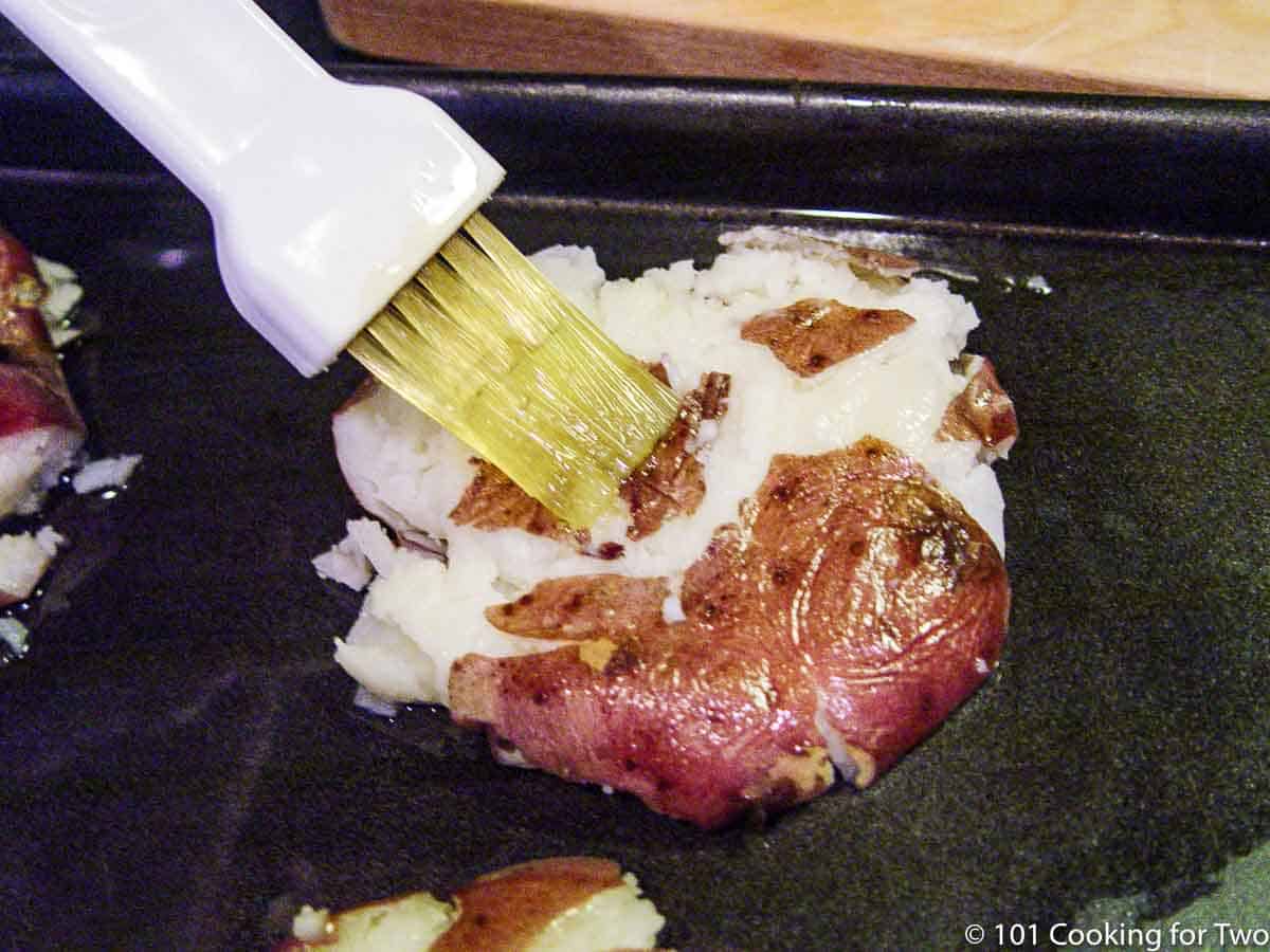 brushing a smashed potato with oil.