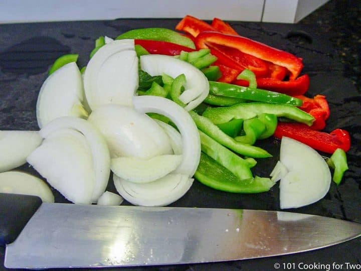 chopped onion with red and green pepper on a black board