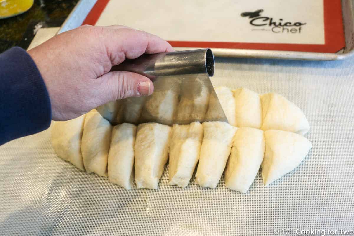 cutting the dough into 16 pieces on a floured surface