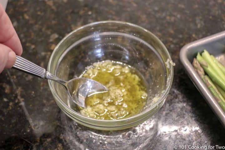 mixing oil and garlic in glass bowl
