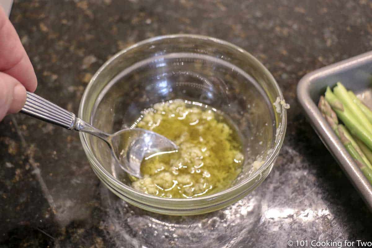 mixing oil and garlic in glass bowl.