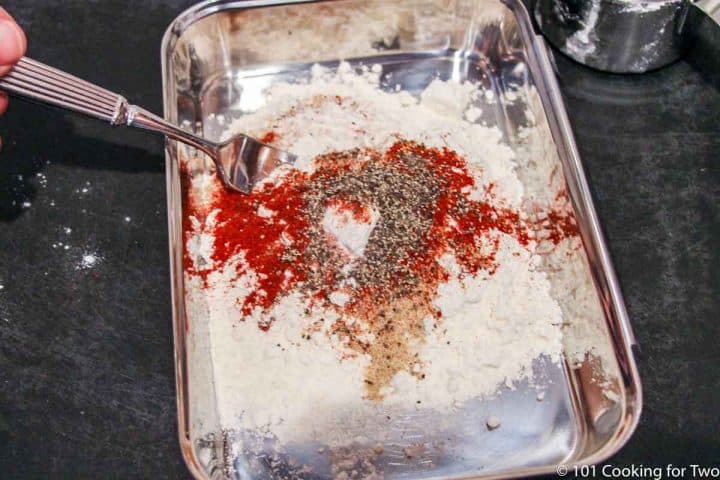 mixing spices with flour in a tray