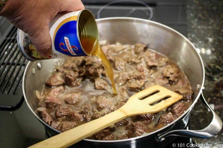 pouring borth into a pan with cooked beef
