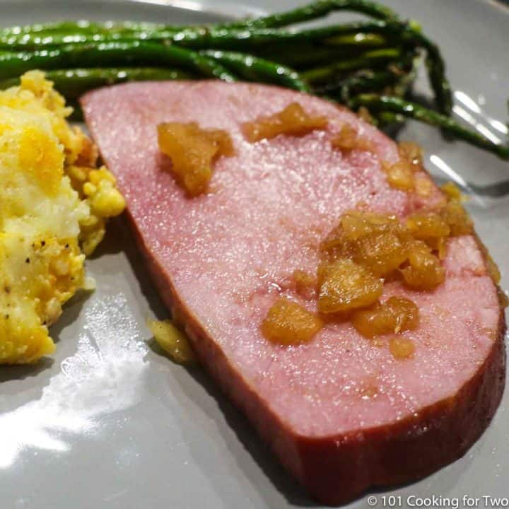 slice of ham on a gray plate with pineapple.