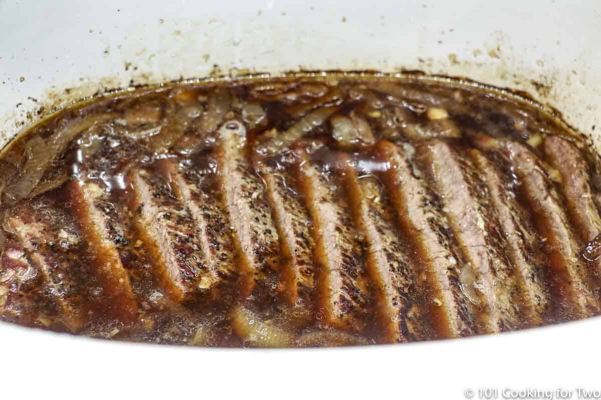 sliced beef roast in the crock pot with liquid