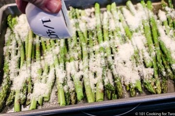 spreading Parmesan cheese on the asparagus