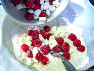adding frozen berries and cream cheese to the dry mixture