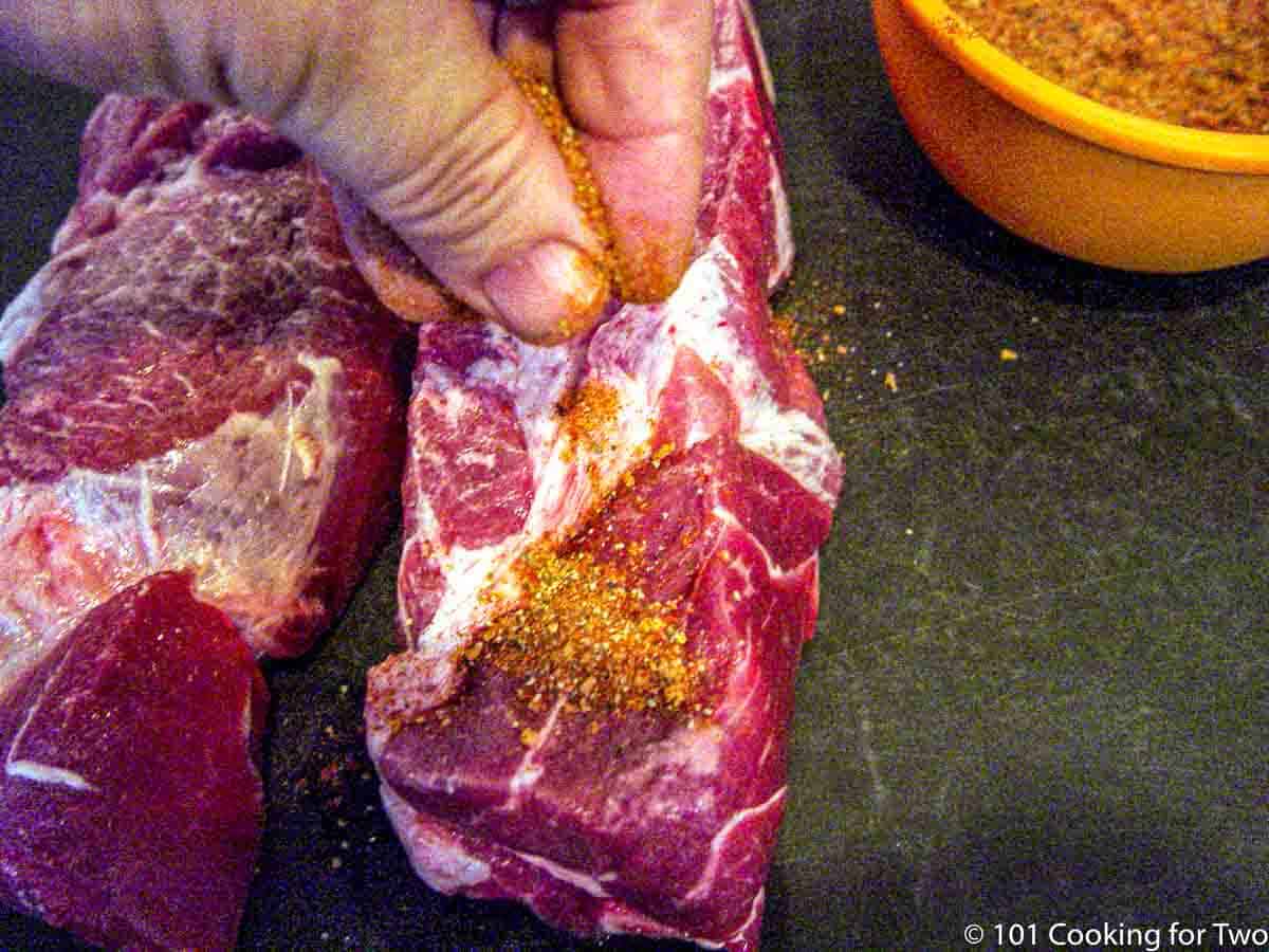 applying rub to the country pork ribs