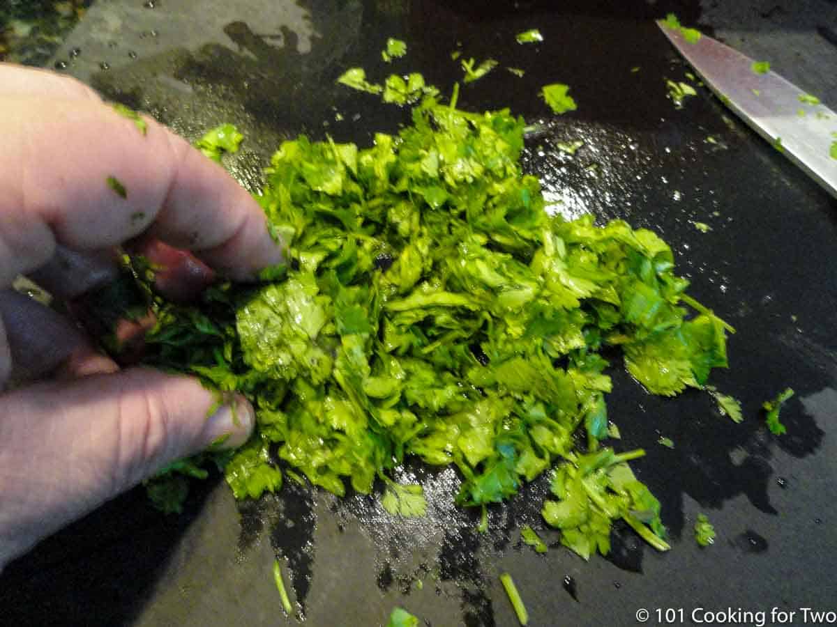 chopping cilantro on a black board