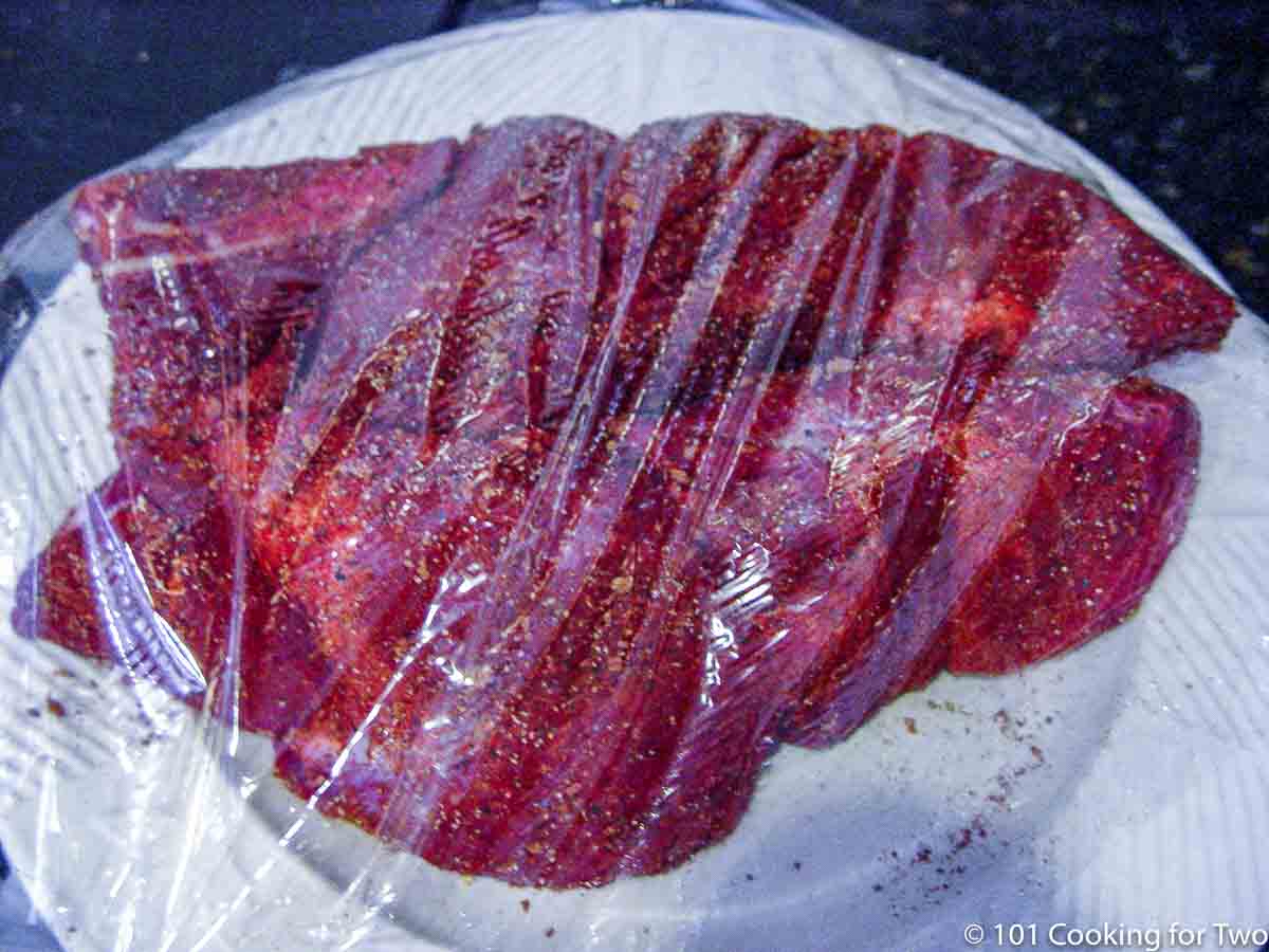 country pork ribs on plate covered with plastic wrap