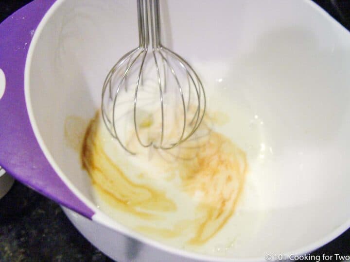 whipping egg with other wet ingredient in a medium bowl
