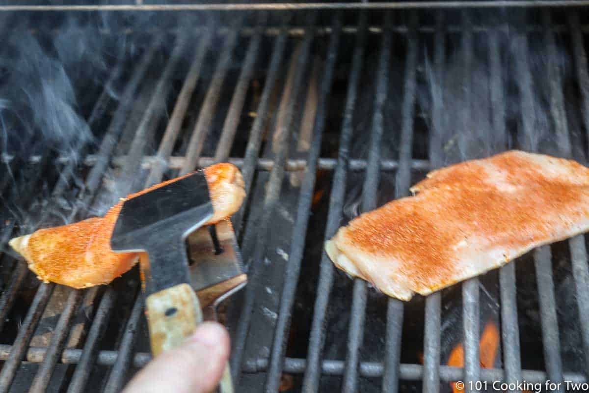 placing seasoned chicken breasts on the grill