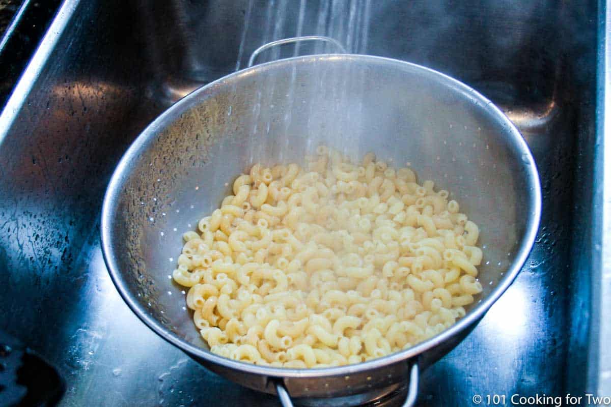 rinsing cooked pasta under running water