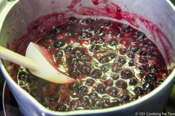 cooked berries with thick sauce in pan.