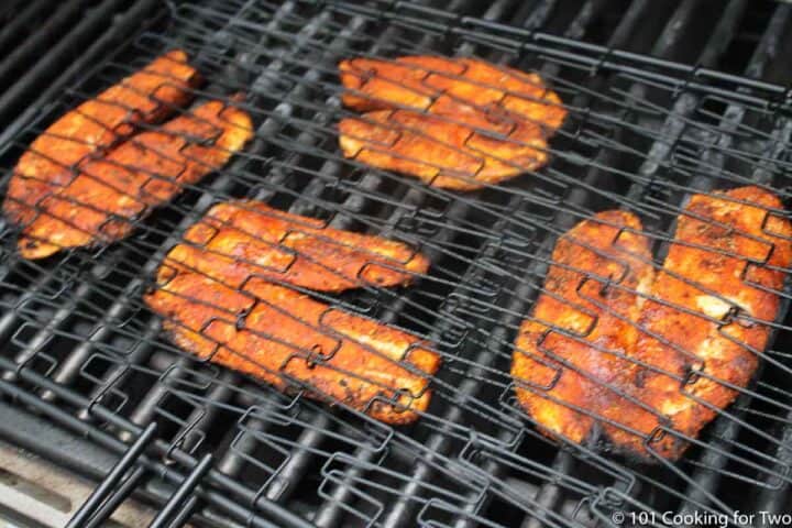 Grilled Blackened Tilapia from 101 Cooking for Two cooked grilled tilapia still in grill basket.