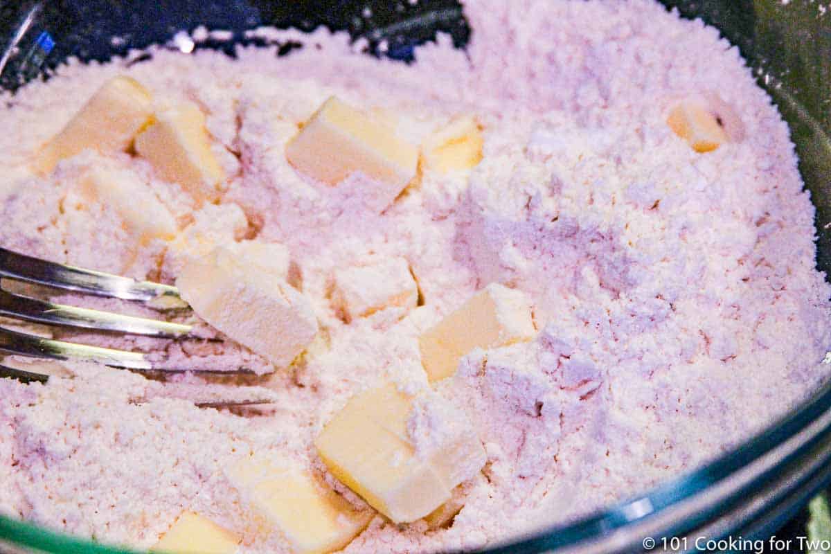 cutting the butter into the topping.