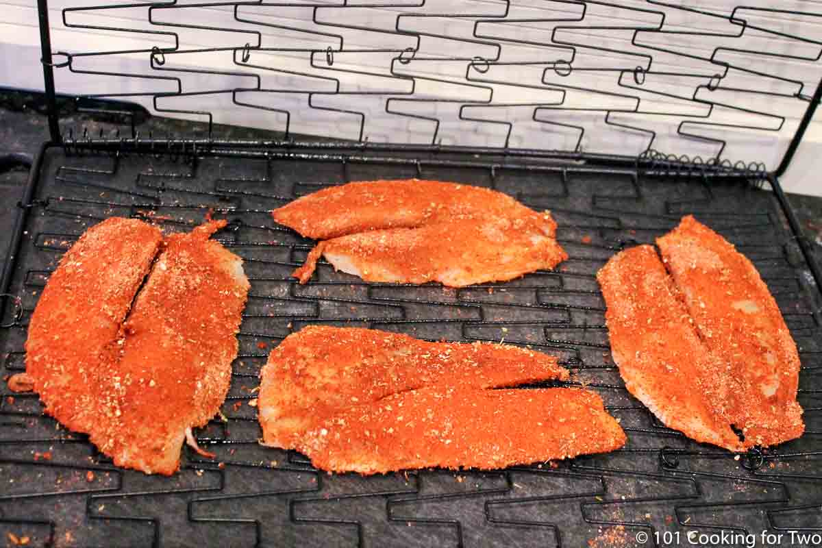 placing spiced fish in grill basket.