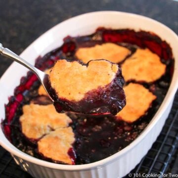 spoonful of cobbler in spoon over bowl.