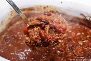 a ladel full of shredded beef chili