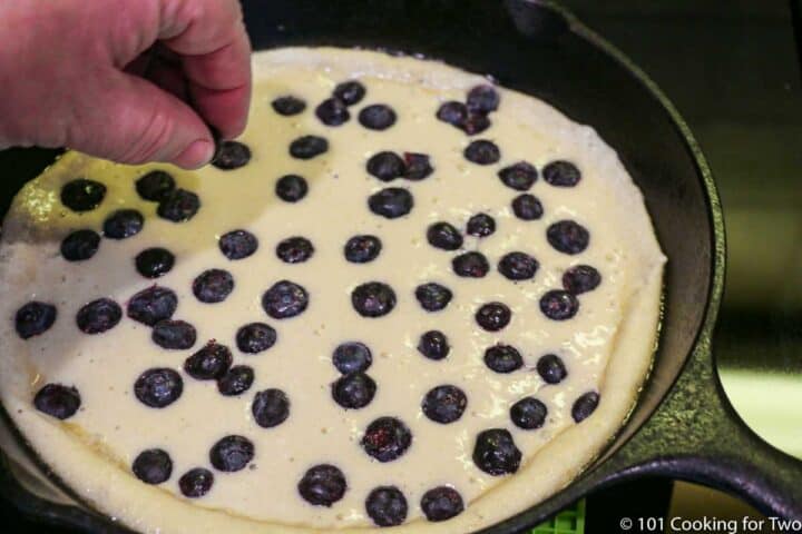 adding blueberries to the top of the batter
