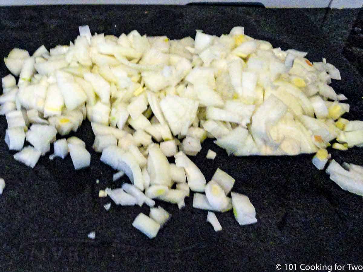 chopped onion on a black board.