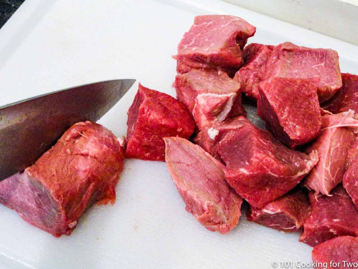 cubes of sirloin steak on a white board.