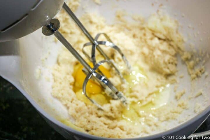 mixing egg into batter with electric mixer