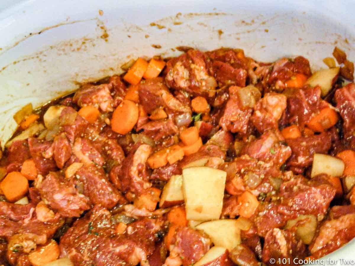 uncooked beef stew in the crock pot.