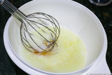 whisking wet ingredients in a white bowl