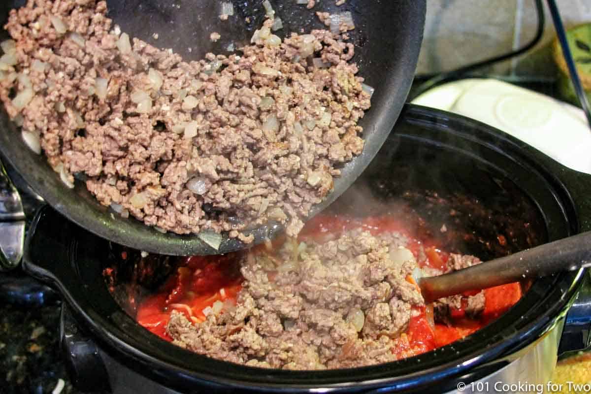 adding browned meat to crock pot.