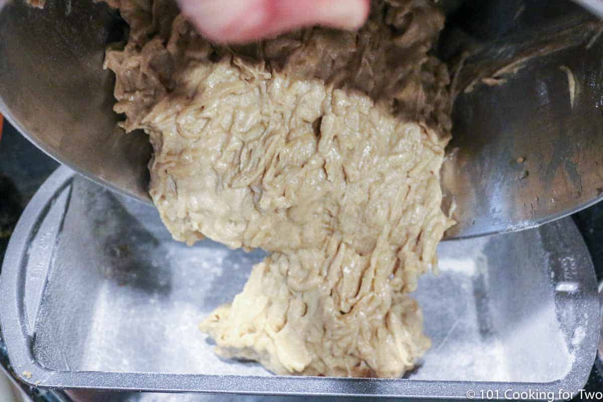 adding dough to floured loaf pan.