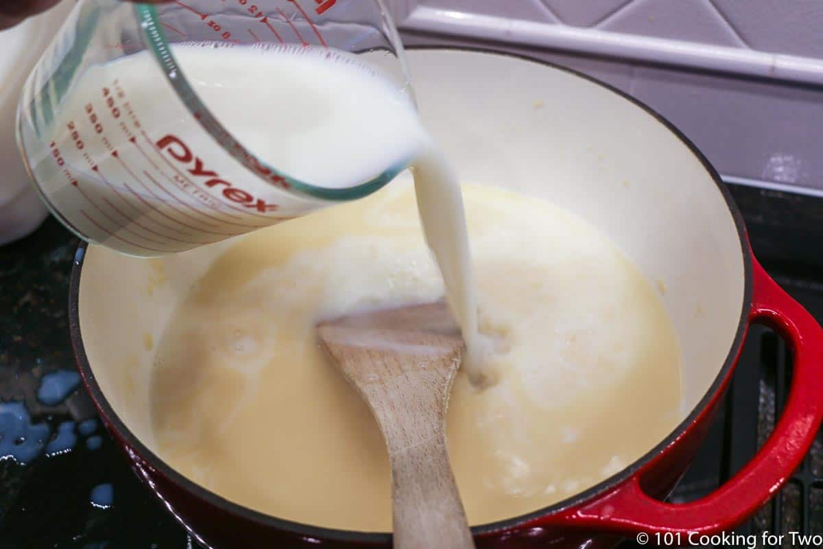 adding milk to the soup pot