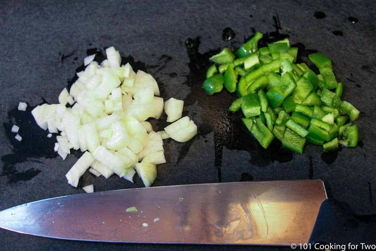 chopped onion and pepper on a black board.
