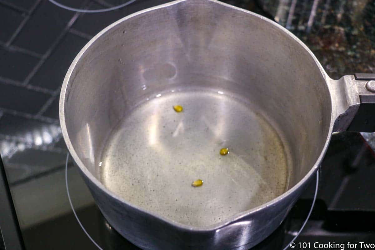 kernals of corn in oil in a pan