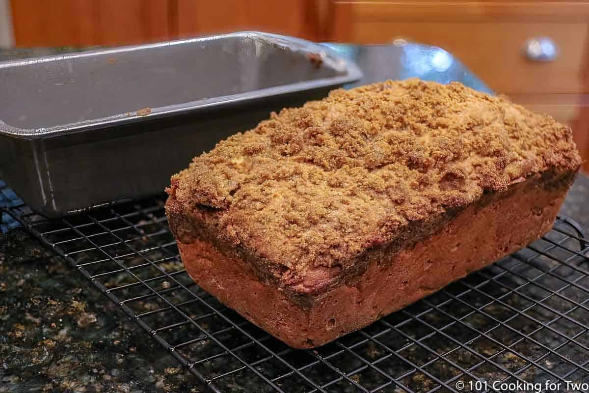 loaf of apple pie bread on a rack.