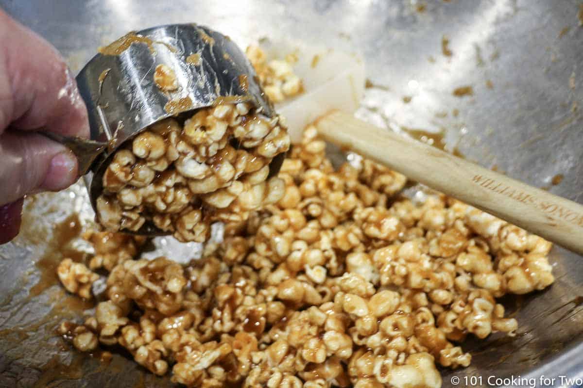 scooping caramel corn with metal cup
