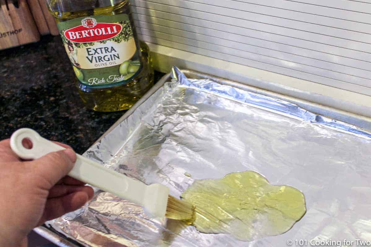 brushing oil on foil covered tray.