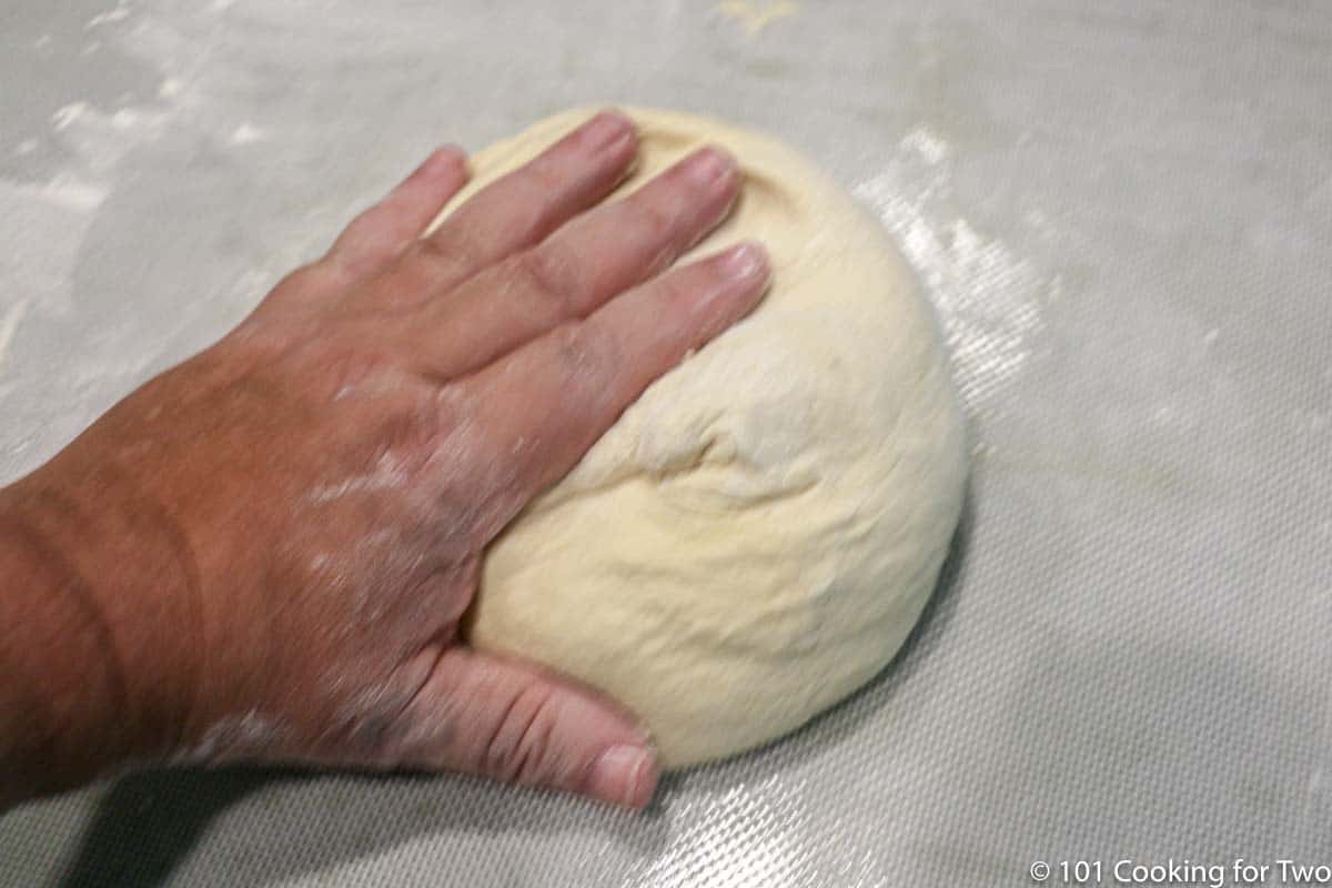kneading dough on a mat.