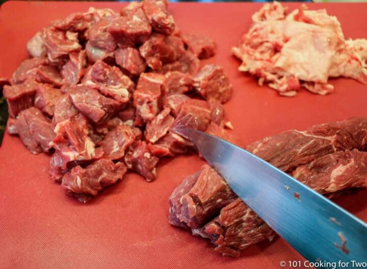 trimming beef on a red board