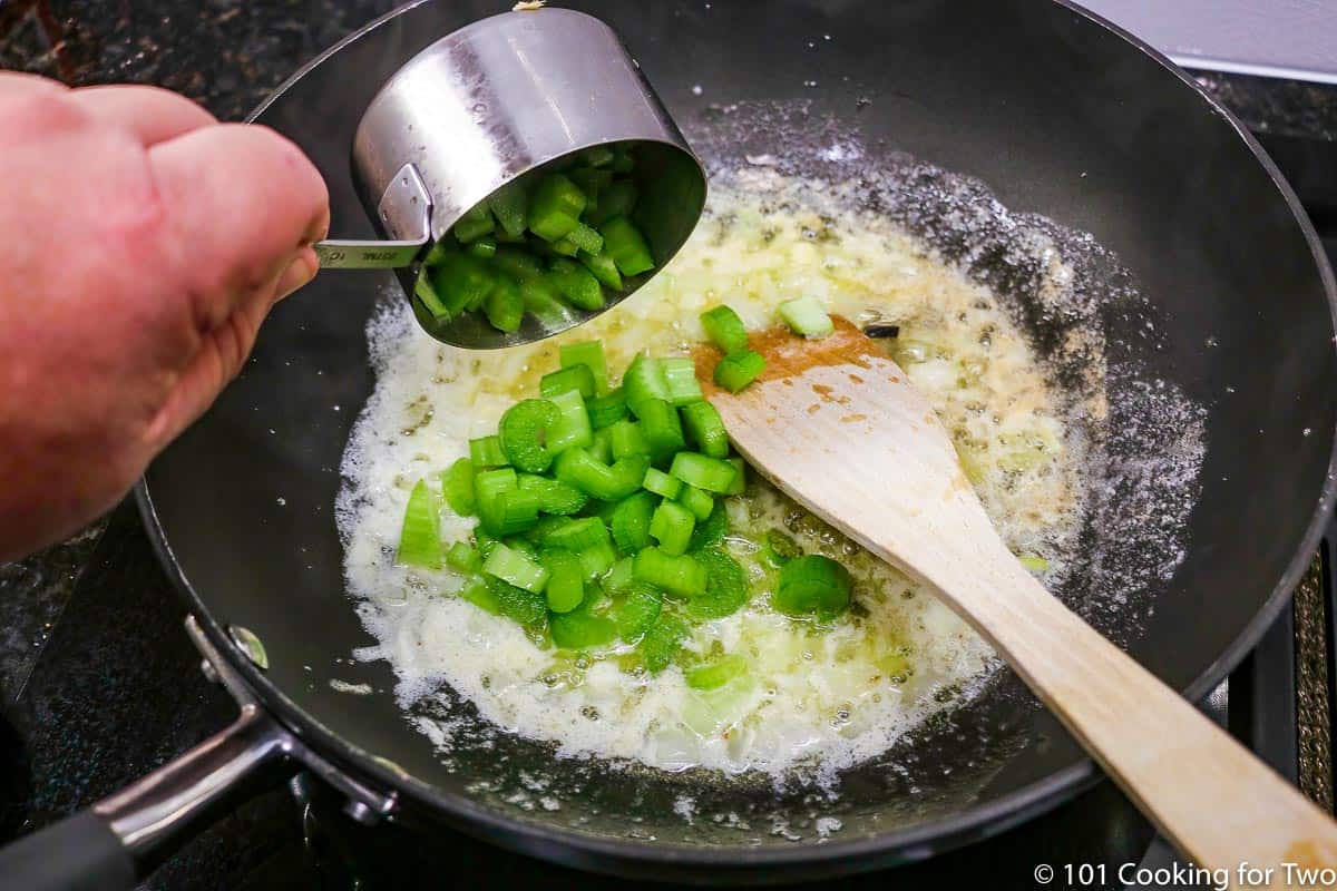 Pouring celery into pan to cook