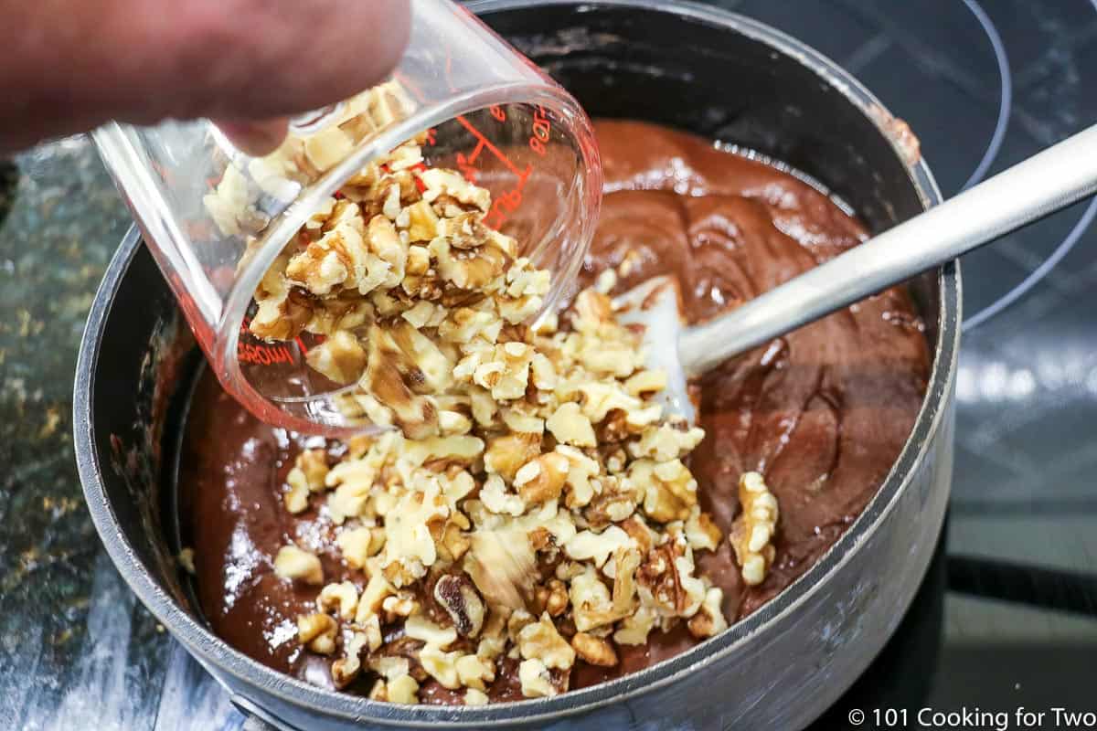 adding chopped walnuts to melted fudge.